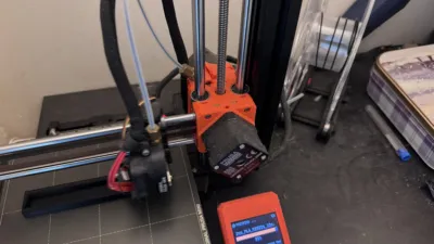 A Prusa Mini 3D printer with the display reporting 95% completion of a print with a filament spool in the background which has three loops of filament remaining before it runs out.