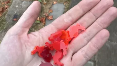 A handful of tiny plastic rabbits in various shades of red.